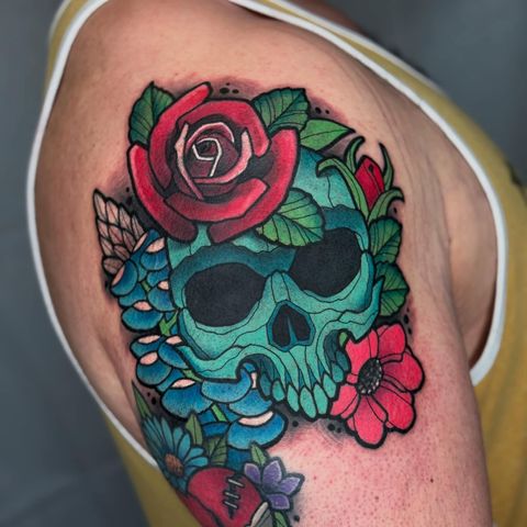 Teal skull with rose and flowers tattoo